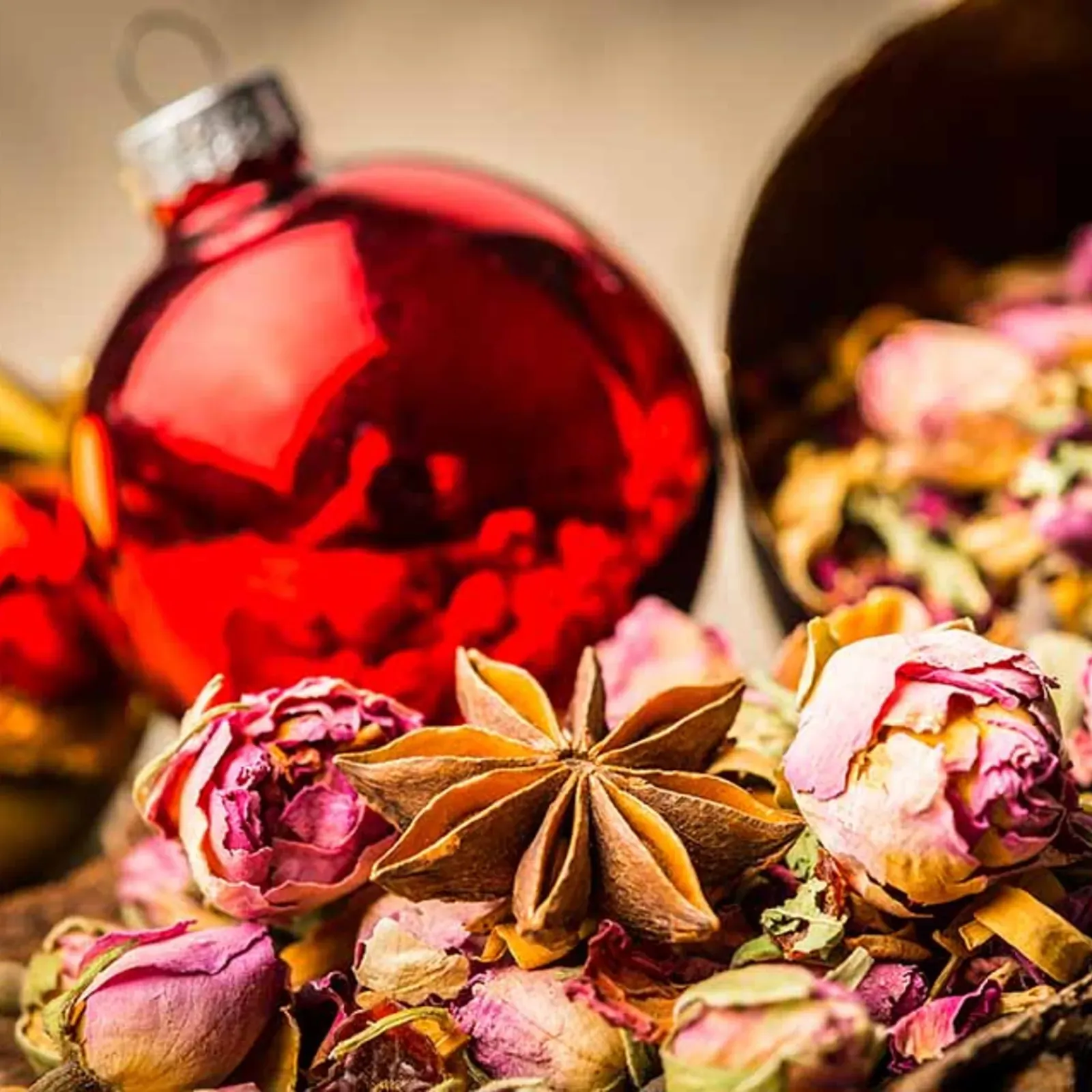 Weihnachtspotpourri mit Rosenknospen, Sternanis und roter Christbaumkugel
