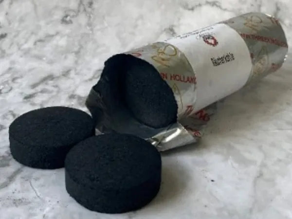Räucherkohle-Tabletten vor einer geöffneten Rolle