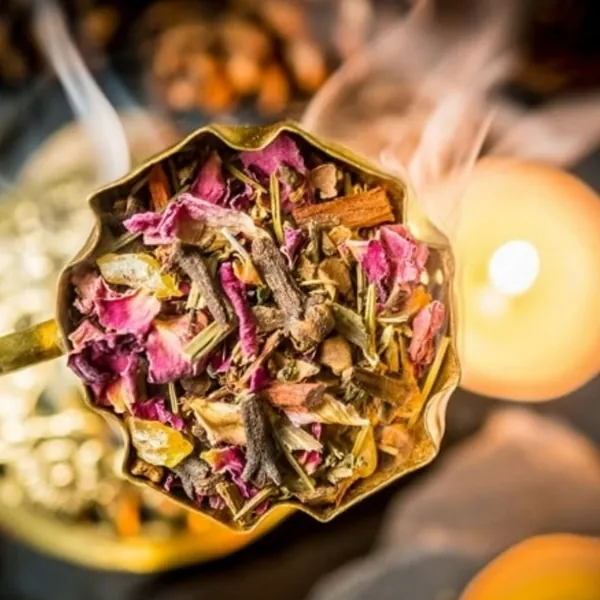 Räuchermischung Raunacht mit Rosenblüten in einer goldenen Schale